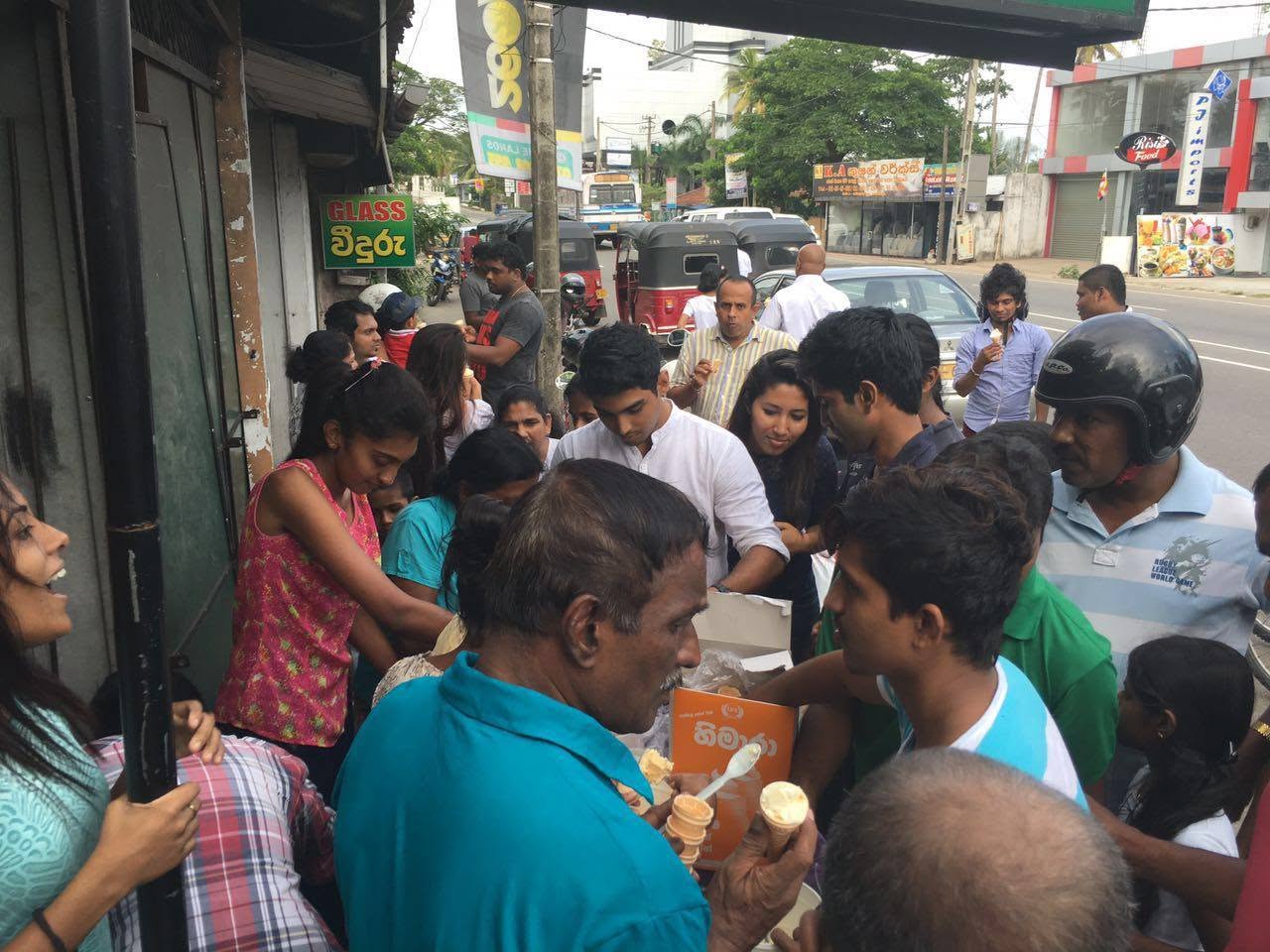 Volunteers distributing ice cream to people at a community Dansala