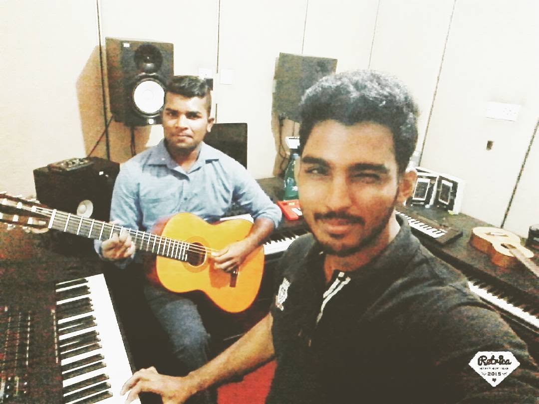 Piumal rehearsing at a keyboard with a guitarist