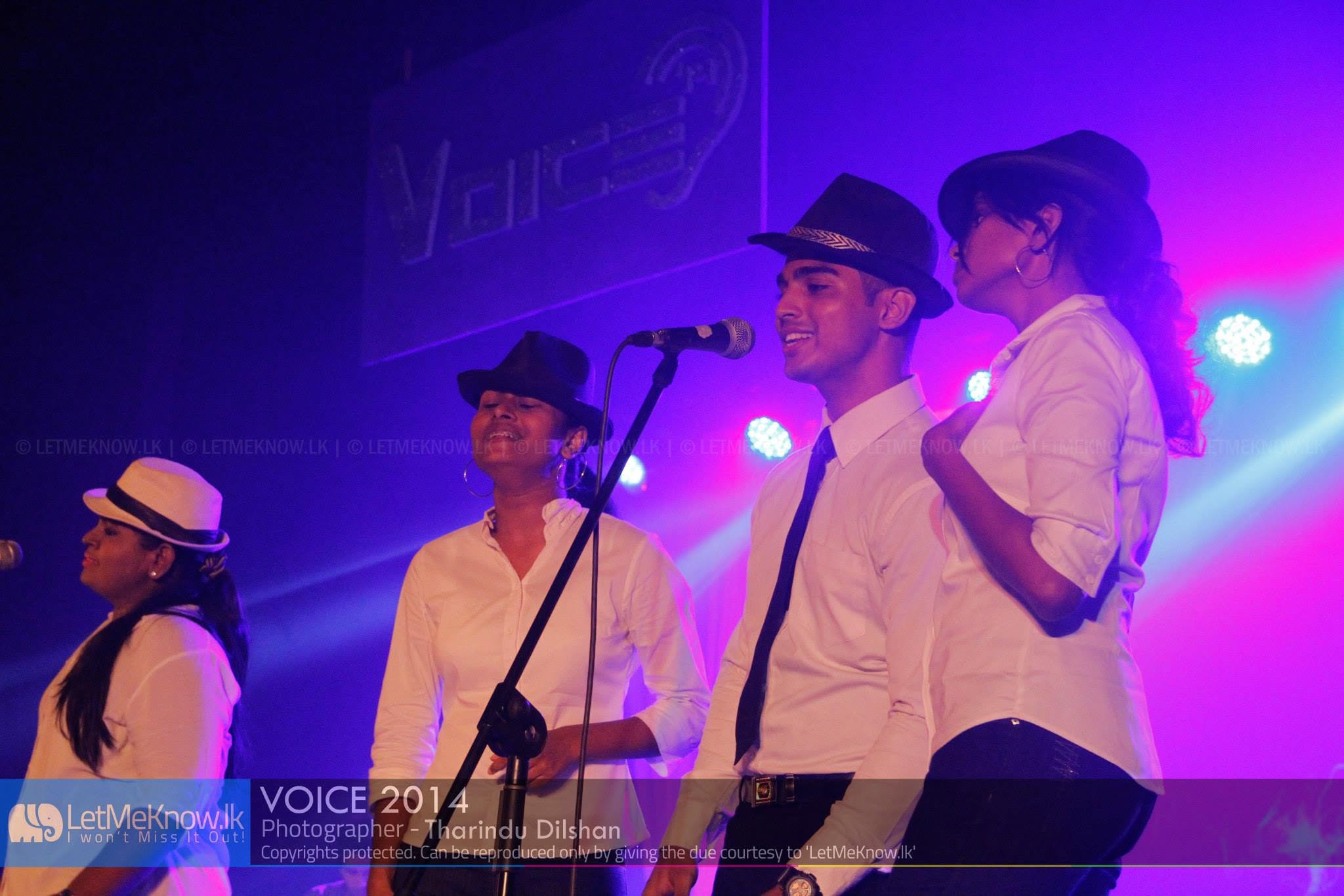 Piumal singing with an ensemble at a live concert