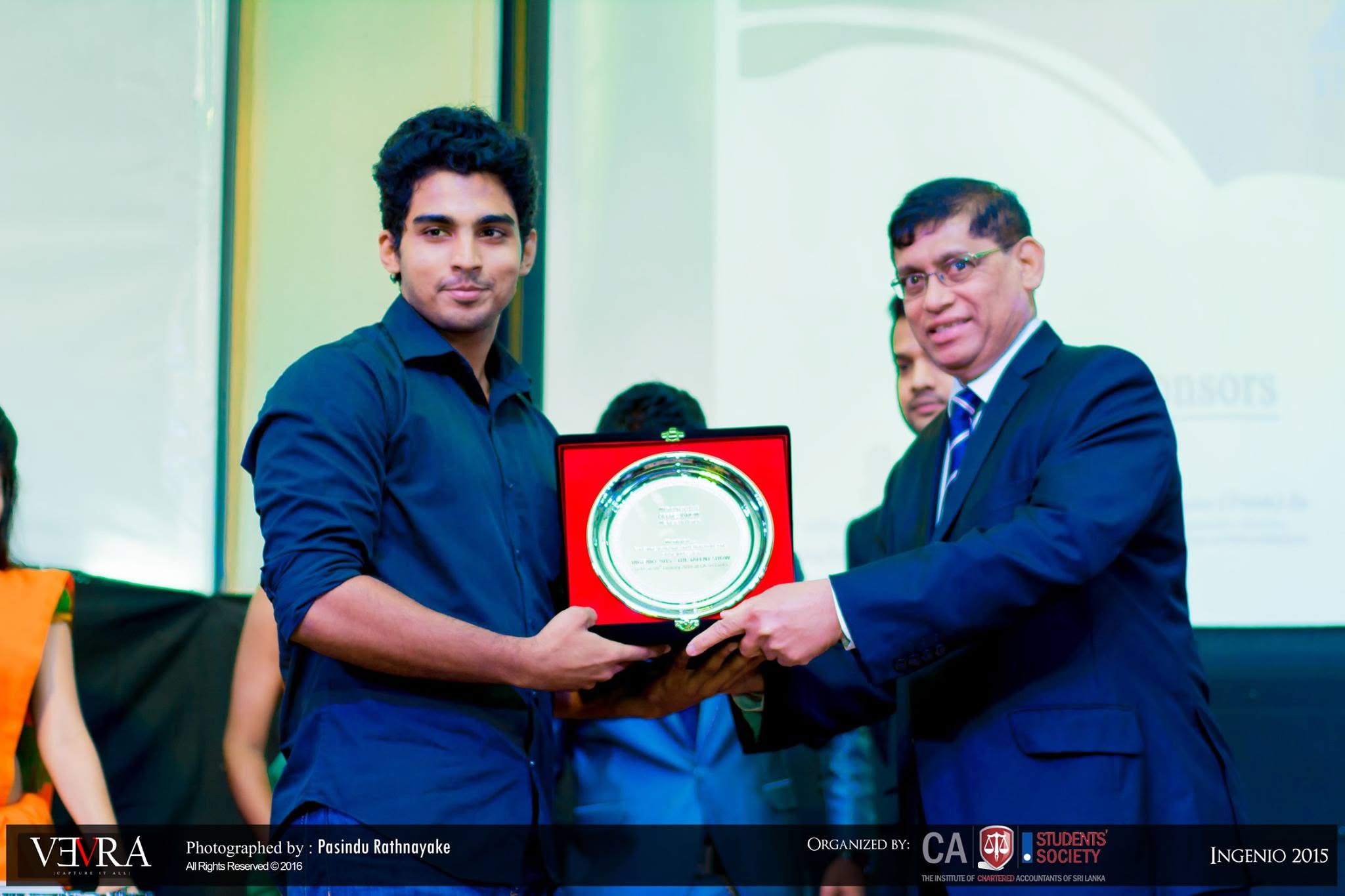 Piumal receiving an appreciation award for serving as a singing competition judge